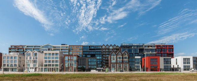   Nằm tại thủ đô Amsterdam của Hà Lan, quần thể kiến trúc này hoạt động giống như một thành phố mini, bao gồm 2000 đơn vị nhà ở, 70 nhà thuyền, một trường học, một khách sạn và một trung tâm y tế.  