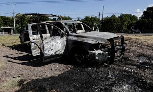 Xe cảnh sát bị đốt sau vụ phục kích của băng đảng ma túy tại khu vực Aguililla, bang Michoacan, Mexico, hôm 14/10. Ảnh: Reuters.