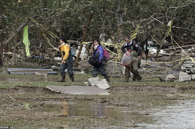 Nhóm nhân viên cứu hộ phải đeo kính và ống thở để tìm kiếm những người mất tích sau cơn bão trong vùng nước cao tới ngang eo lưng tại Nagano, miền Trung Nhật Bản.