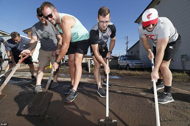 Các thành viên đội bóng bầu dục Canada giúp đỡ người dân Nhật Bản dọn dẹp bùn đất. 