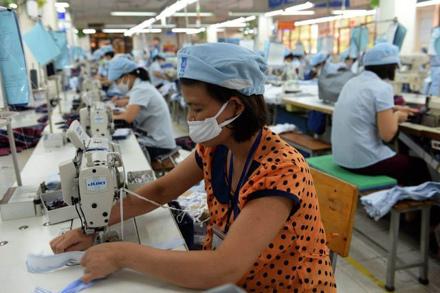 Một công nhân đang làm việc tại nhà máy may mặc ở Hà Nội. Ảnh: Bloomberg.