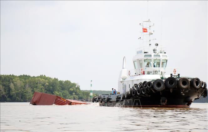 Phương tiện lai dắt container vào tập kết gần bờ, tạo thông thoáng cho lòng sông Lòng Tàu. Ảnh: TTXVN