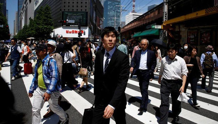   Người bộ hành trên đường phố ở quận kinh doanh trung tâm Tokyo - Ảnh: Reuters.  