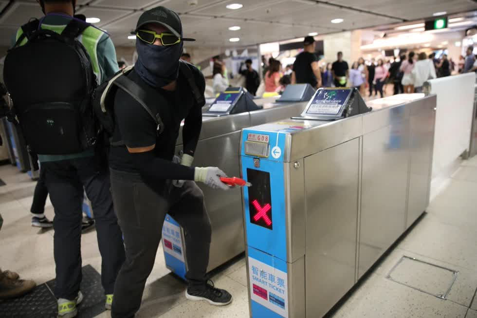 Người biểu tình đập phá các cửa soát vé trong một ga tàu điện ngầm ở Hồng Kông. Ảnh: Winson Wong/SCMP.