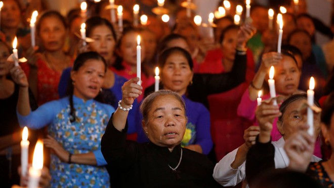 Các tín đồ ở nhà thờ làng Mỹ Khánh, Cần Thơ, giơ nến cầu nguyện cho 39 nạn nhân thiệt mạng trong xe container ở Anh hôm 26/10. Ảnh: Reuters.