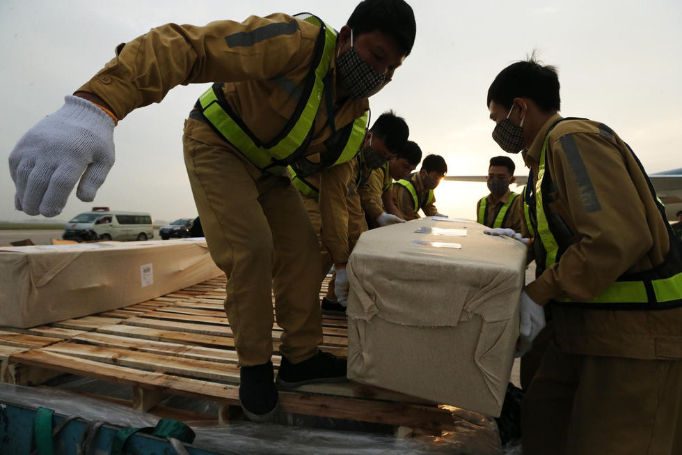 Nhân viên sân bay quốc tế Nội Bài vận chuyển thi thể các nạn nhân lên ôtô để đưa về quê nhà. Ảnh: Bộ Ngoại Giao.