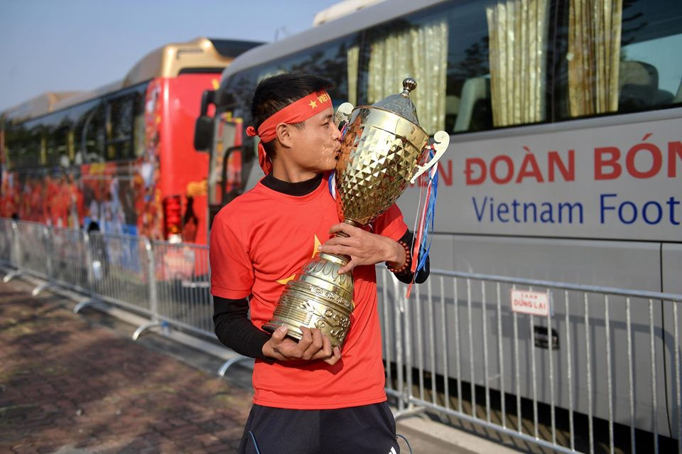  Hình ảnh người hâm mộ ôm cúp vàng tại sân bay Quốc tế Nội Bài.  