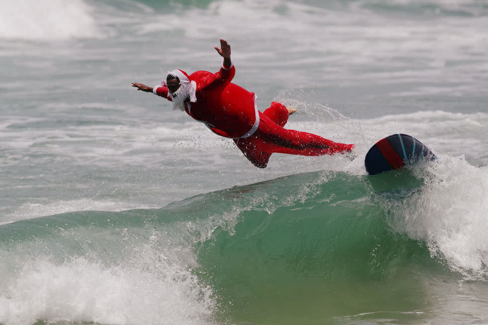 Carlos Bahia, hóa trang thành ông già Noel, lướt sóng tại bãi biển Maresias ở Sao Sebastiao, Brazil, vào ngày 15/12. Ảnh:  Reuters.