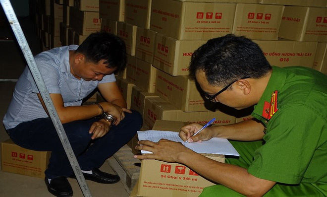 Trần Minh Hải (chủ cơ sở làm giả nước ngọt) làm việc cùng công an.
