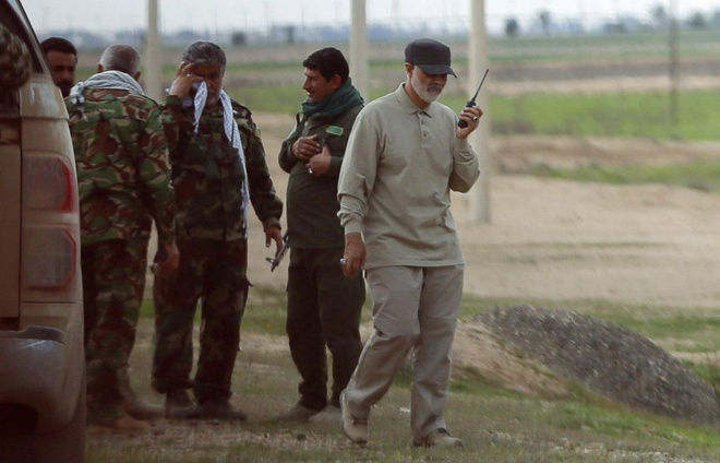 Tướng Soleimani (cầm bộ đàm) trong một lần xuất hiện trên biên giới Syria. Một quan chức cấp cao Iraq từng nói với BBC rằng phản ứng kịp thời của Iran đã giúp ngăn chặn sự sụp đổ của quân đội Iraq trong cuộc chiến với IS.