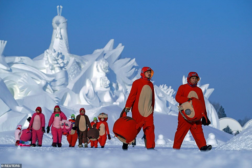  Các vũ công trong trang phục rời đi sau khi kết thúc màn trình diễn của họ cho Lễ hội điêu khắc băng tuyết quốc tế Cáp Nhĩ Tân. 