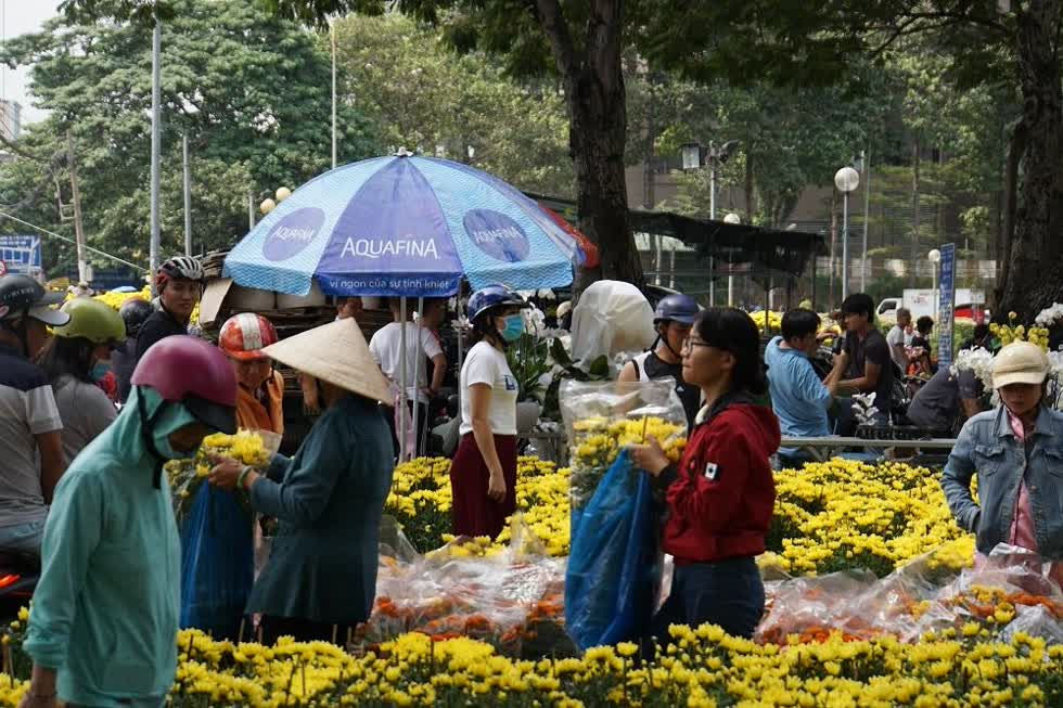 Cảnh mua bán khẩn trương hơn giữa trưa khi ban quản lý chợ hoa liên tục phát loa thông báo các tiểu thương chuẩn bị hoàn trả mặt bằng.