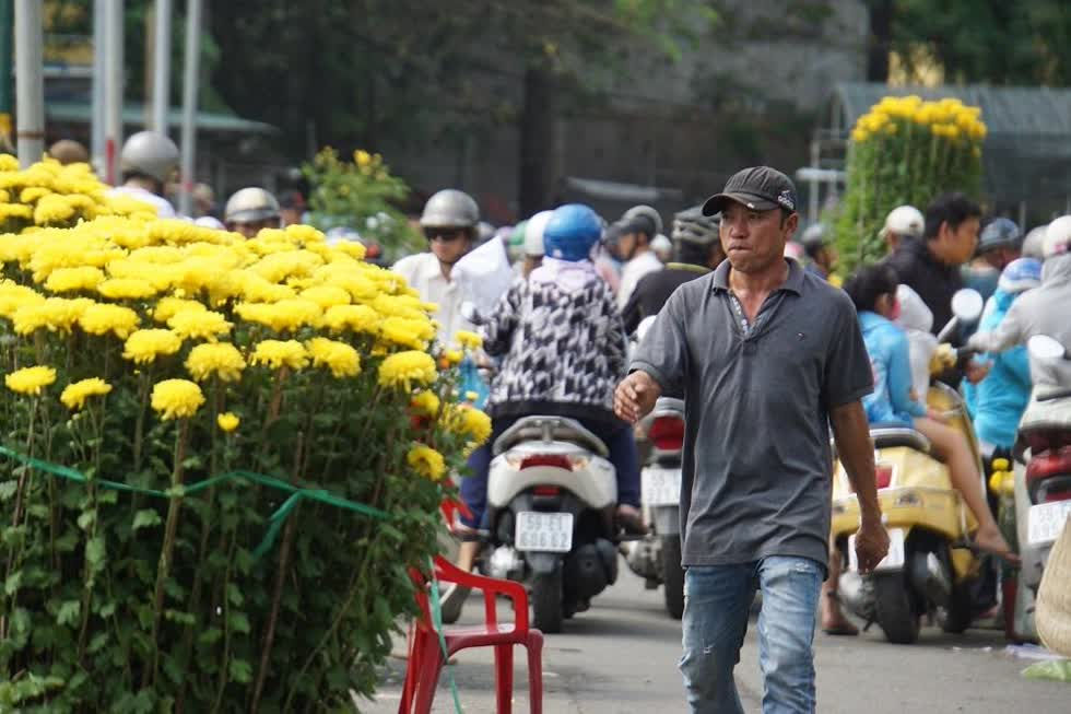 Anh Sơn (41 tuổi, quê Khánh Hòa) buồn bã cho biết đưa vào Sài Gòn gần 300 chậu hoa cúc các loại nhưng bán chưa được một nửa. 