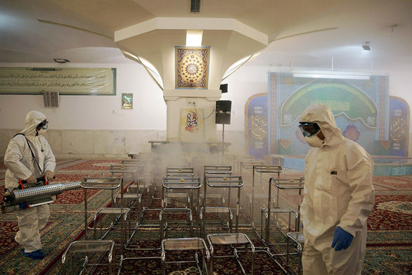 Xịt khử trùng tại một ngôi đền ở Iran - Ảnh: REUTERS.