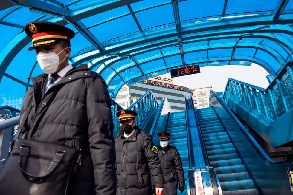  Các nhân viên trên tàu đeo khẩu trang đi xuống ga tàu Bắc Kinh. Cư dân Bắc Kinh đến từ tỉnh Hồ Bắc cũng bị hỏi nhiều lần là đã đi những đâu gần đây hay có người thân tới thăm hay không (quê quán được ghi trên căn cước).