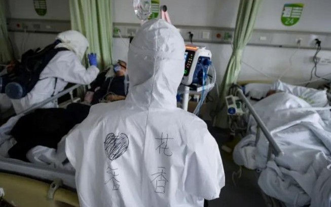   Nhân viên y tế mặc đồ bảo hộ chăm sóc bệnh nhân nhiễm virus corona tại một phòng cách ly một bệnh viện ở Vũ Hán, tỉnh Hồ Bắc (Trung Quốc) ngày 6/2. Ảnh: REUTERS  