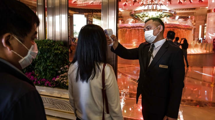   Một nhân viên kiểm tra nhiệt độ của khách du lịch tại lối vào sòng bạc và khách sạn Galaxy Macau vào ngày 24/1/ 2020.  