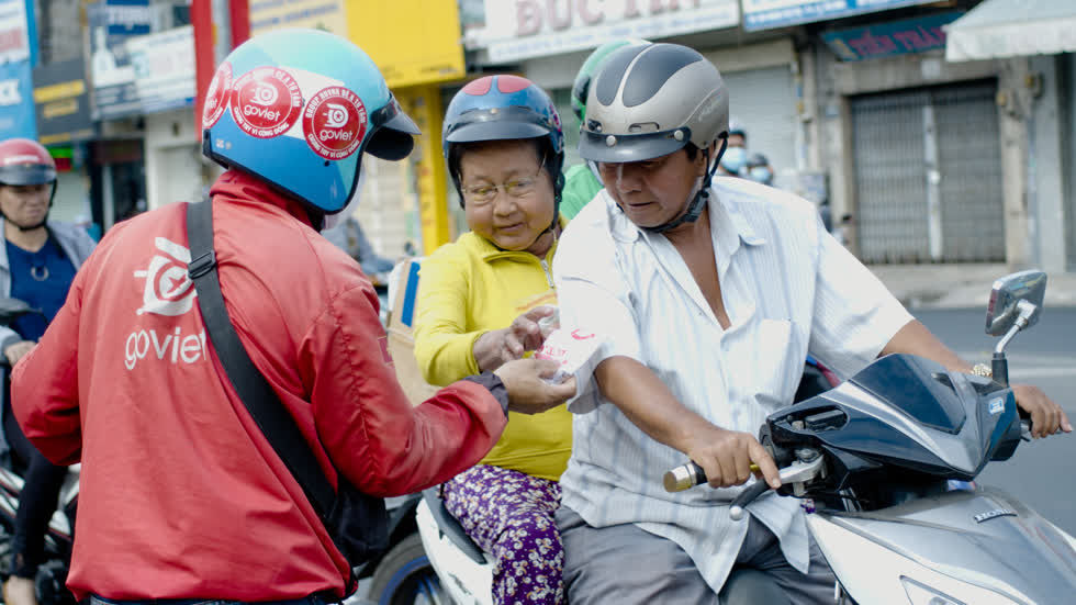 Hình ảnh của các anh lái xe ôm công nghệ tự nguyện trích thu nhập của mình, xếp hàng từ 4 giờ sáng để mua được 3000 khẩu trang phát miễn phí cho người dân ở ngã tư Bảy HIền (quận Tân Bình). 