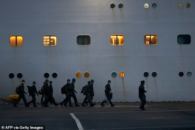   Lực lượng phòng vệ Nhật Bản đi bộ qua tàu du lịch Diamond Princess ngay trước khi cuộc di tản bắt đầu.  