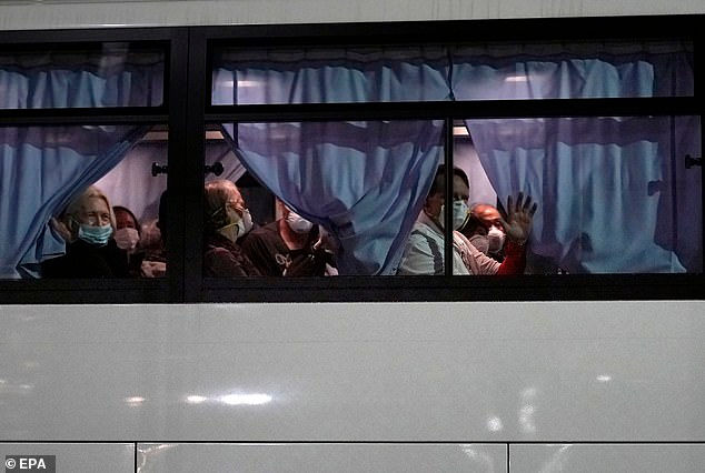   Công dân Mỹ vẫy tay từ một chiếc xe buýt khi họ rời tàu du lịch Diamond Princess cập cảng Daikoku Pier Cruise.  