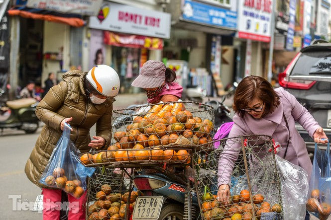 Khách hàng vừa mua nước cam lẫn cam tươi về dùng. Ảnh: Tiền Phong.