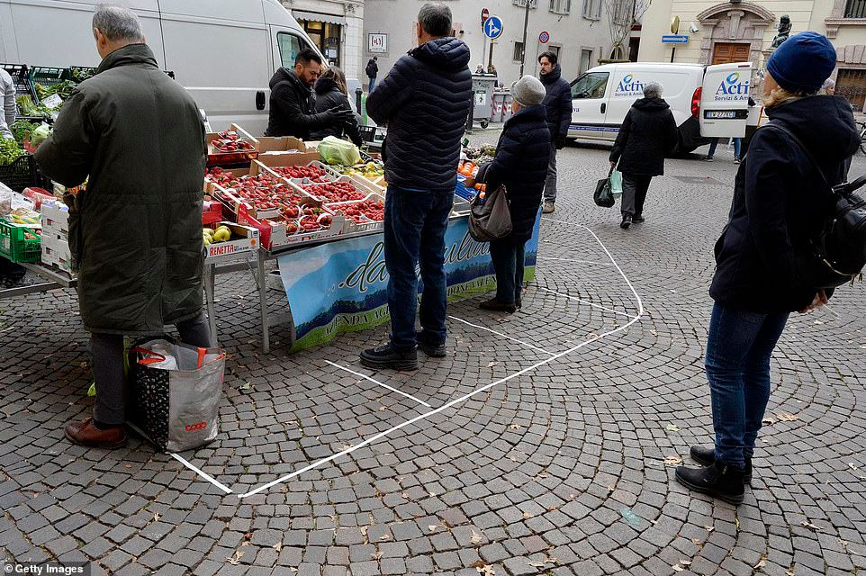   Các điểm đánh dấu trên sàn cho thấy khoảng cách an toàn giữa những người mua tại quầy hàng ở chợ là một phần của các biện pháp kiểm soát chống lại sự lây lan của virus corona ở Trento vào ngày 11/3.   