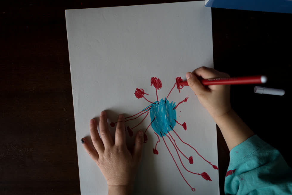   Bianca Toniolo vẽ một bức tranh về coronavirus trong khi cô và gia đình ở nhà. Ảnh: Reuters.  