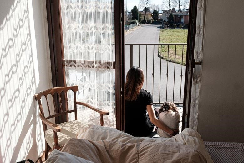   Cô Chiara Zuddas, 31 tuổi và con gái 2 tuổi Bianca Toniolo ngồi ở ban công tại ngôi nhà của họ ở San Fiorano, một trong những thị trấn bị phong toả do lây lan COVID-19. Ảnh: Reuters  