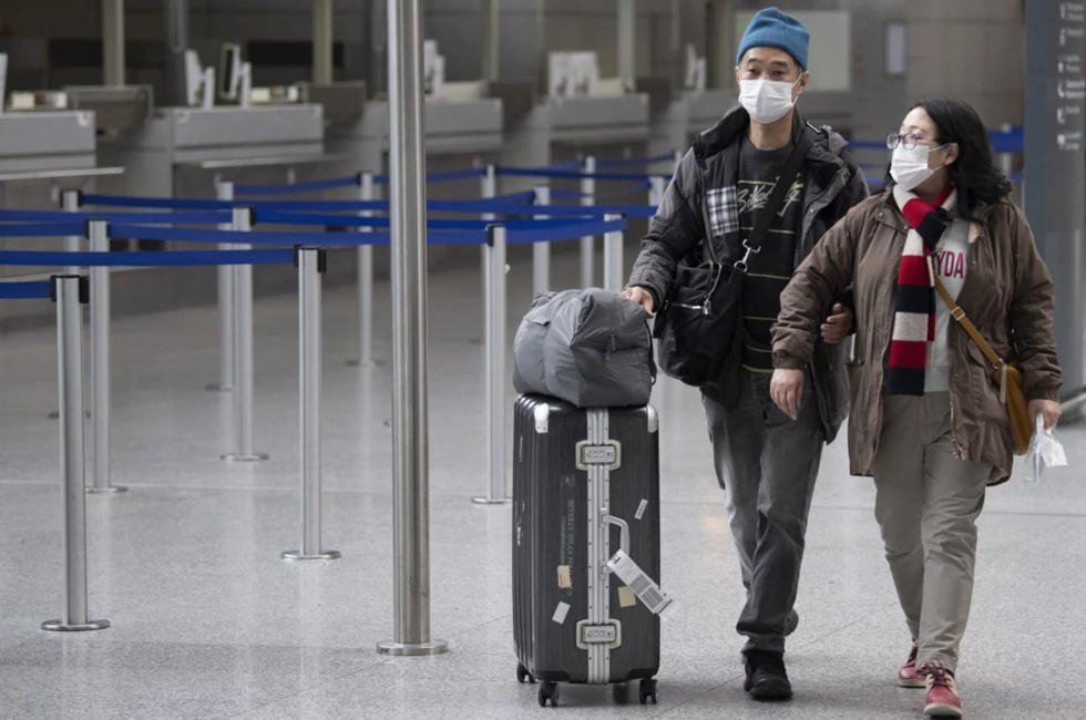   Hành khách đeo mặt nạ đi qua nhà ga tại sân bay Frankfurt ở Đức. Ảnh: AP  