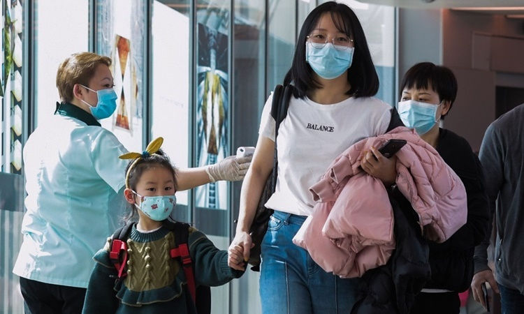 Nhân viên y tế kiểm tra thân nhiệt hành khách tại sân bay quốc tế Changi, Singapore, hồi cuối tháng hai. Ảnh:AFP.