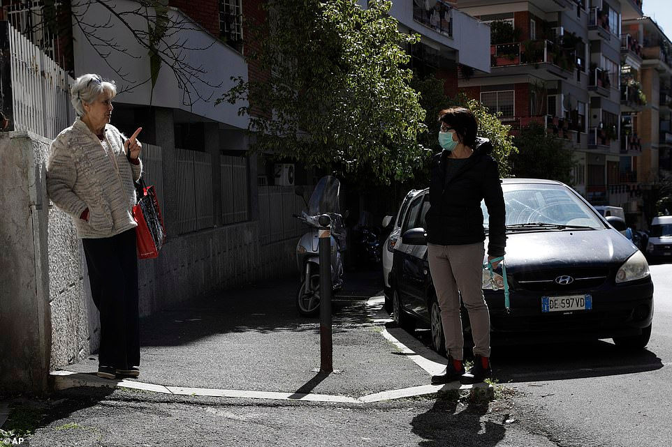   Bà Enza Garzia (trái), 79 tuổi, nói chuyện phải đứng cách xa với bà Paola Albano, người hàng xóm của mình ở miền trung Rome vào ngày 11/3. Ngay sau khi virus xuất hiện ở miền bắc Italy vào ngày 21/2.  