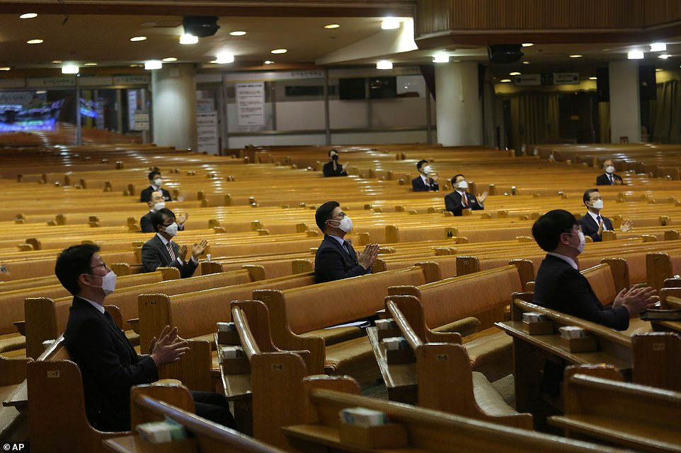 Người dân đeo khẩu trang đi lễ tại một nhà thờ ở Seoul, Hàn Quốc. Mọi người tuân thủ ngồi cách xe nhau từ 1 đến 2m.
