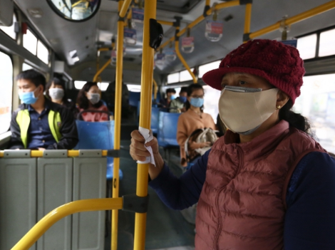 Hành khách thực hiện đeo khẩu trang khi tham gia giao thông trên xe buýt công cộng. Ảnh: TTXVN