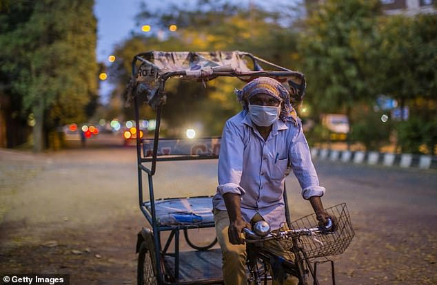   Một người kéo xe kéo Ấn Độ đang chờ đợi hành khách trên một con đường vắng, giữa lúc bị phong tỏa do virus corona trên toàn quốc ngày hôm nay (25/3.)  