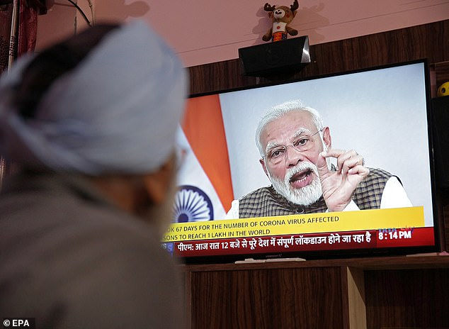   Một người đàn ông Ấn Độ theo dõi thủ tướng Narendra Modi tuyên bố phong tỏa 21 ngày trên toàn quốc để ngăn chặn sự lây lan của virua corona.  