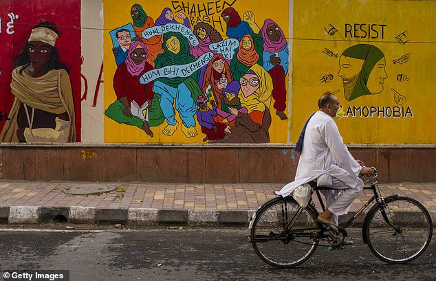   Một người đàn ông với khẩu trang bảo vệ cưỡi một chiếc xe đạp trên con đường vắng, giữa một cuộc phong tỏa trên toàn quốc đối với virus corona ở New Delhi.  