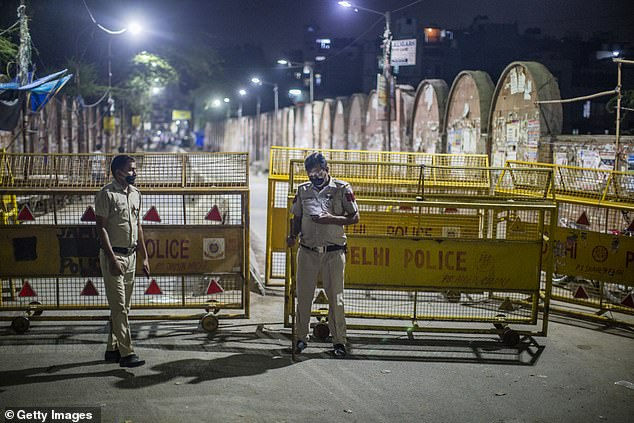   Cảnh sát Ấn Độ đứng gác trên một trung tâm thương mại bỏ trống ở New Delhi khi họ thi hành lệnh phong tỏa của chính quyền Delhi như một biện pháp phòng ngừa chống lại COVID-19.  