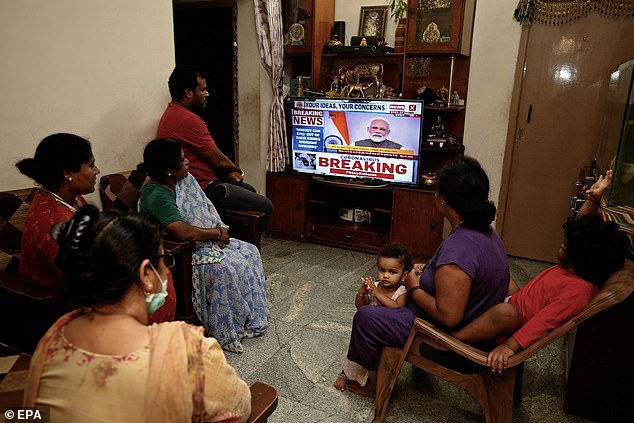   Một gia đình theo dõi qua truyền hình, ông Modi tuyên bố phong tỏa toàn quốc bắt đầu từ rang sáng 25/3.  