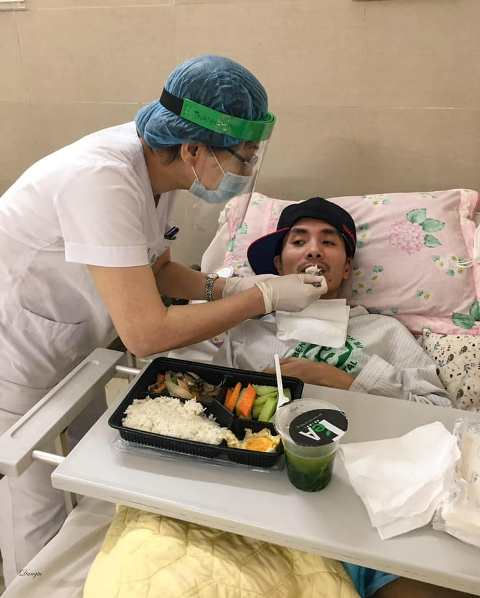 Y tá hỗ trợ bệnh nhân trong việc ăn uống.