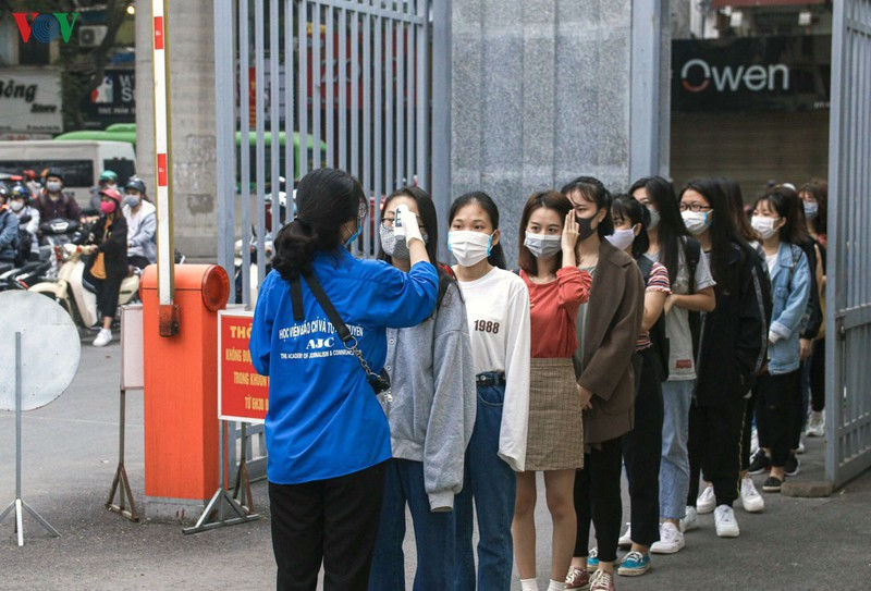   Tại Học viện Báo chí và Tuyên truyền, sinh viên được kiểm tra thân nhiệt trước khi vào trường.   