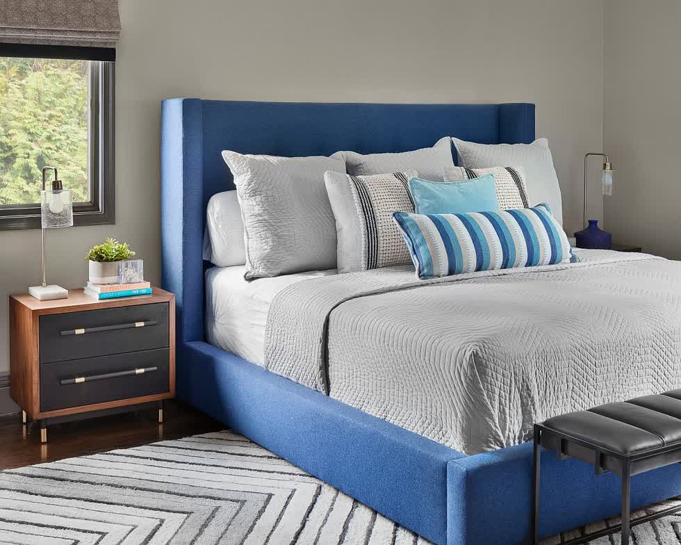   Giường thoải mái với màu xanh kết hợp với tấm thảm sặc sỡ với hoa văn chevron cho phòng ngủ nhỏ.  
