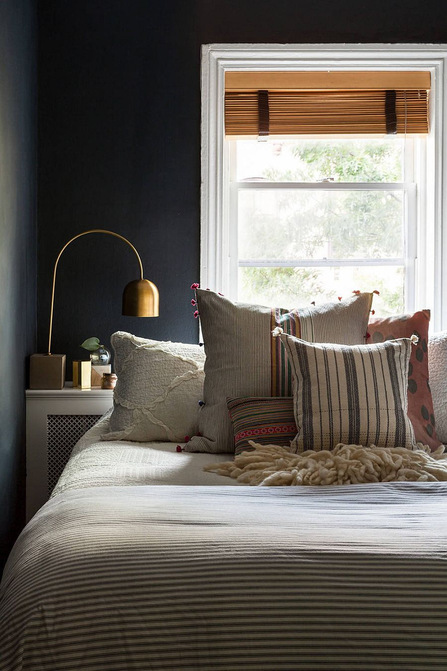 Phông nền màu xám đậm trong phòng ngủ nhỏ tạo cho nó một phong cách hiện đại.