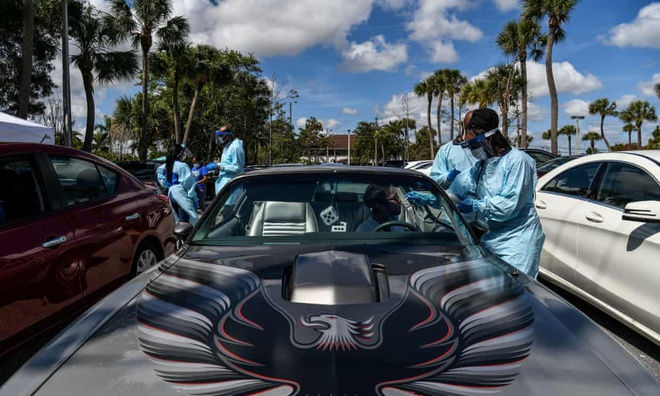 Nhân viên y tế lấy mẫu thử tại trạm xét nghiệm virus corona trên xe ở West Palm Beach, Florida. Ảnh: AFP.