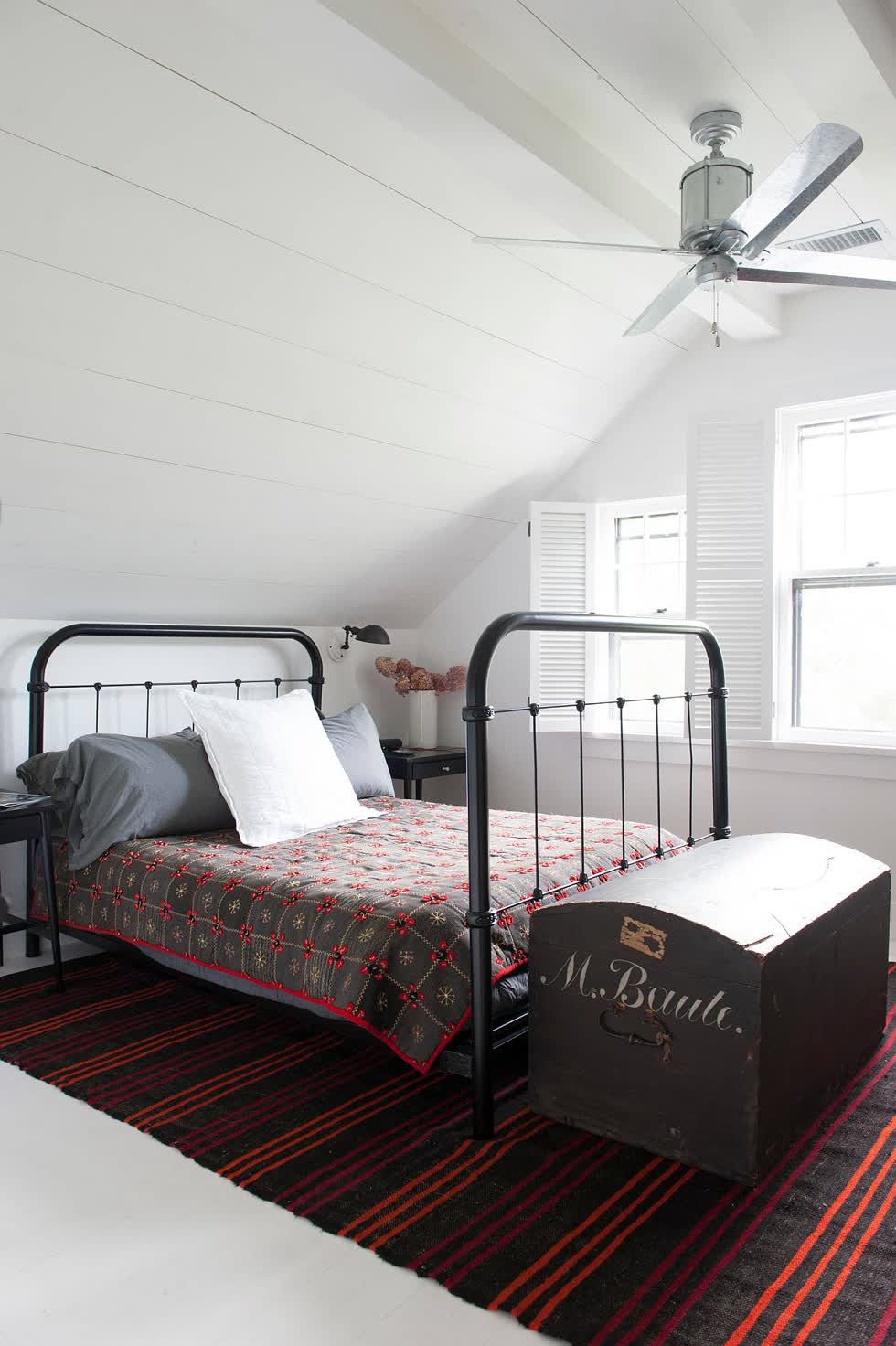 Phòng ngủ tầng áp mái của ngôi nhà ở New York với phong cách trang trí hiện đại và tấm thảm phản chiếu ánh sáng.