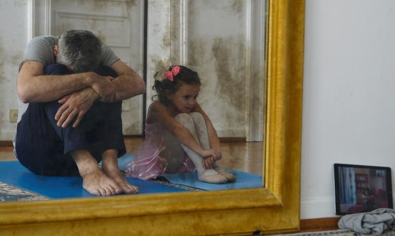 Pal, 41 tuổi và con gái Marilou, 4 tuổi, phản chiếu trong gương khi họ tập múa ba lê ở nhà khi tình trang phong tỏa ở Brussels, Bỉ.