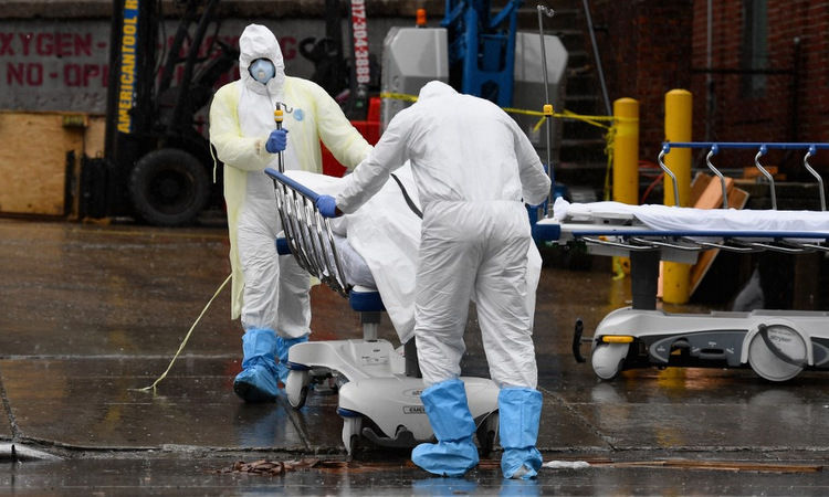   Nhân viên y tế Mỹ đưa thi thể bệnh nhân ra xe đông lạnh tại New York hôm 9/4. Ảnh: AFP.  