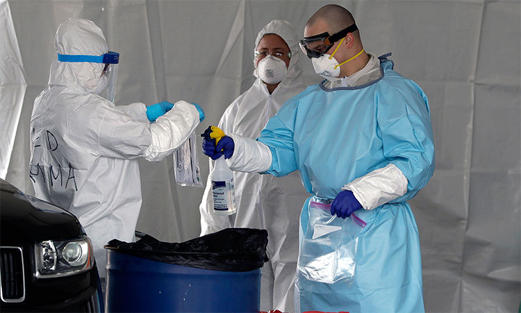   Nhân viên y tế phun dung dịch sát khuẩn lên túi đựng mẫu bệnh phẩm xét nghiệm nCoV tại trạm lưu động ở Foxborough, Massachusetts ngày 5/4. Ảnh: AP.  