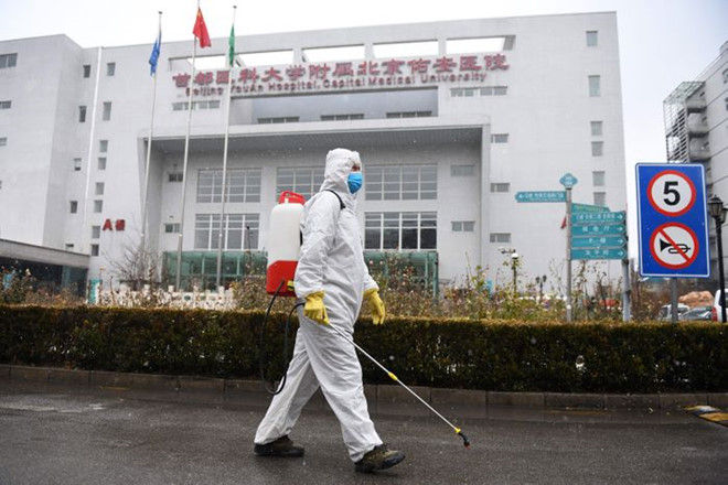 Nhân viên làm vệ sinh trước một bệnh viện ở thủ đô Bắc Kinh, Trung Quốc. Ảnh: Reuters