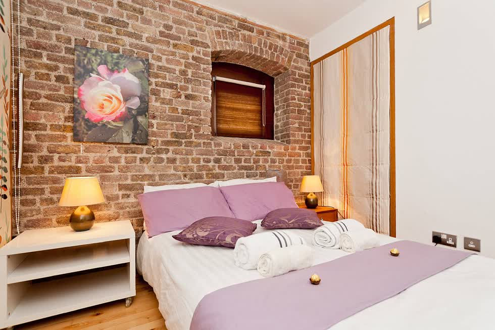 Nội thất tùy chỉnh của phòng ngủ nhỏ với phông nền tường gạch đáng yêu.