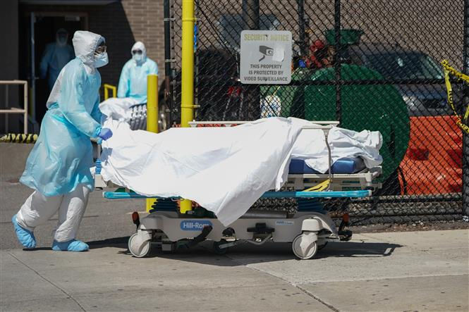 Nhân viên y tế chuyển thi thể bệnh nhân mắc COVID-19 ra nhà xác dã chiến bên ngoài một bệnh viện ở New York, Mỹ ngày 6/4/2020. Ảnh: TTXVN.